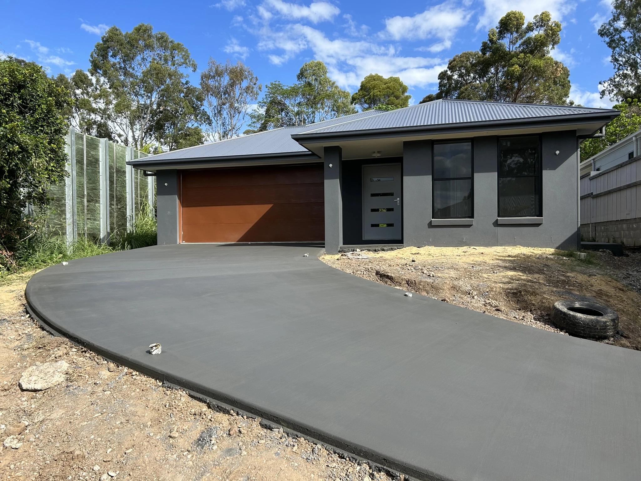 Curved concrete driveway completed for a modern residential home on the Sunshine Coast